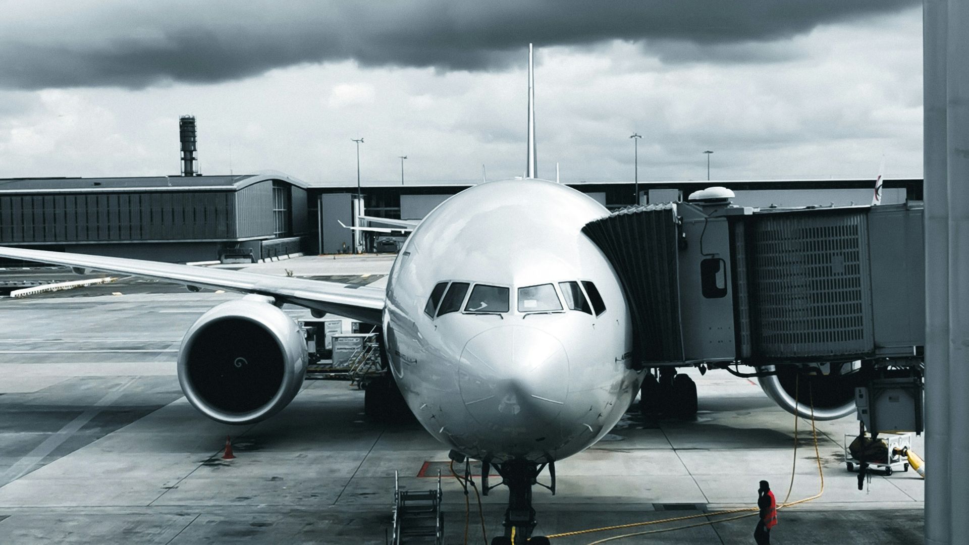 Commercial aircraft parked at an airport gate with ground support equipment during aerospace and airline facility operations.