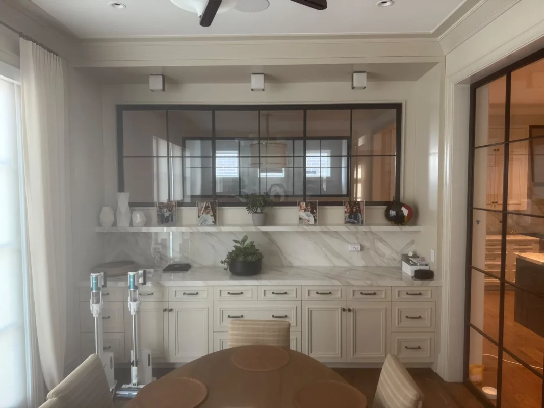 Bathroom remodel featuring a double vanity, stone surfaces and framed mirrors.