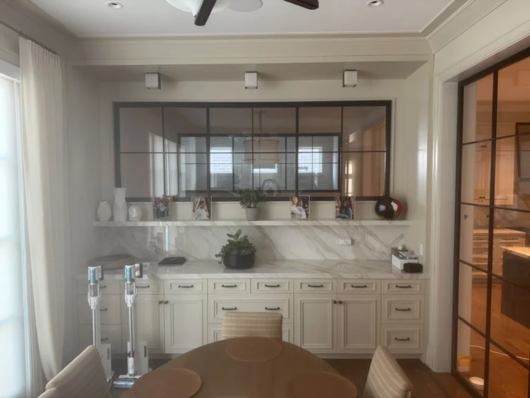Bathroom remodel featuring a double vanity, stone surfaces and framed mirrors.