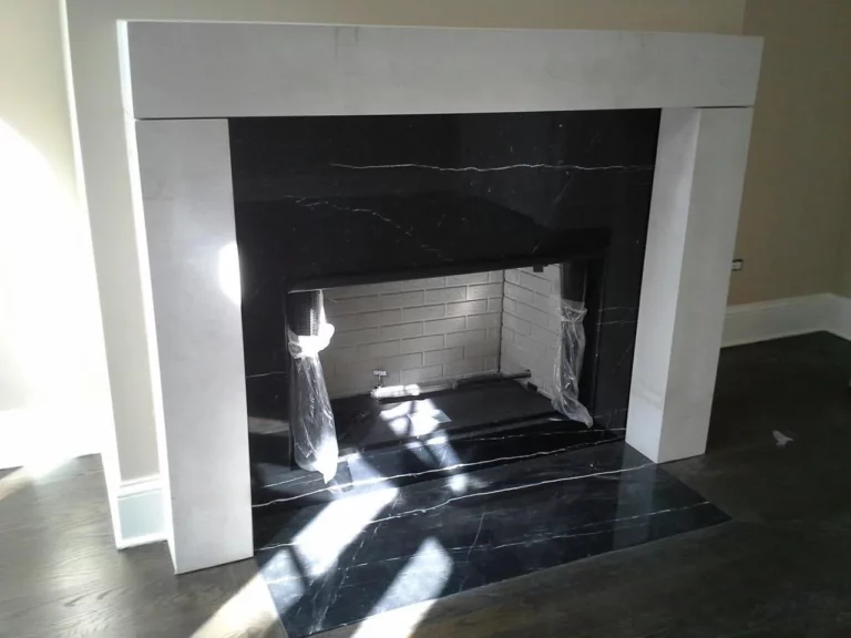 Black stone fireplace surround framed by a white mantel.