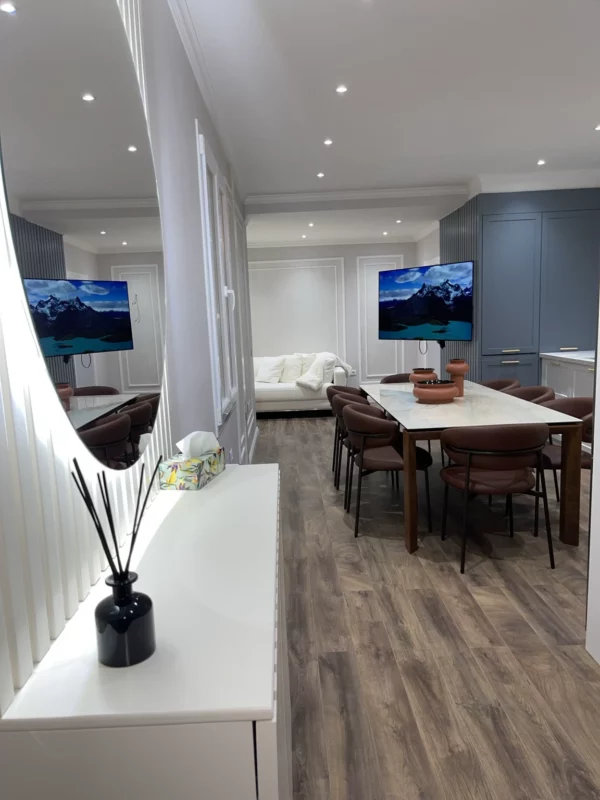 A wider view of the same kitchen remodel, showing the dining area, decorative wall molding and connection to the living space.