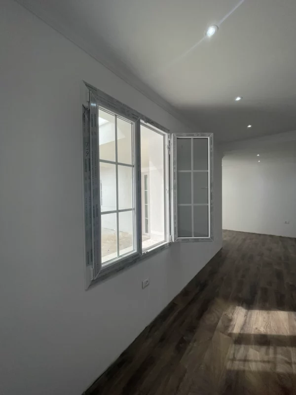 New casement window shown open, with protective frame film still in place during the renovation.