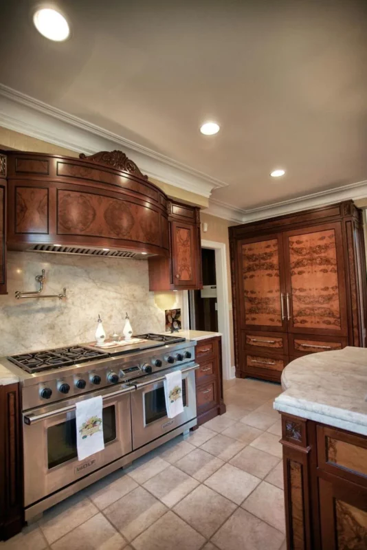 Traditional kitchen with wood cabinetry, stone counters and a tiled floor.